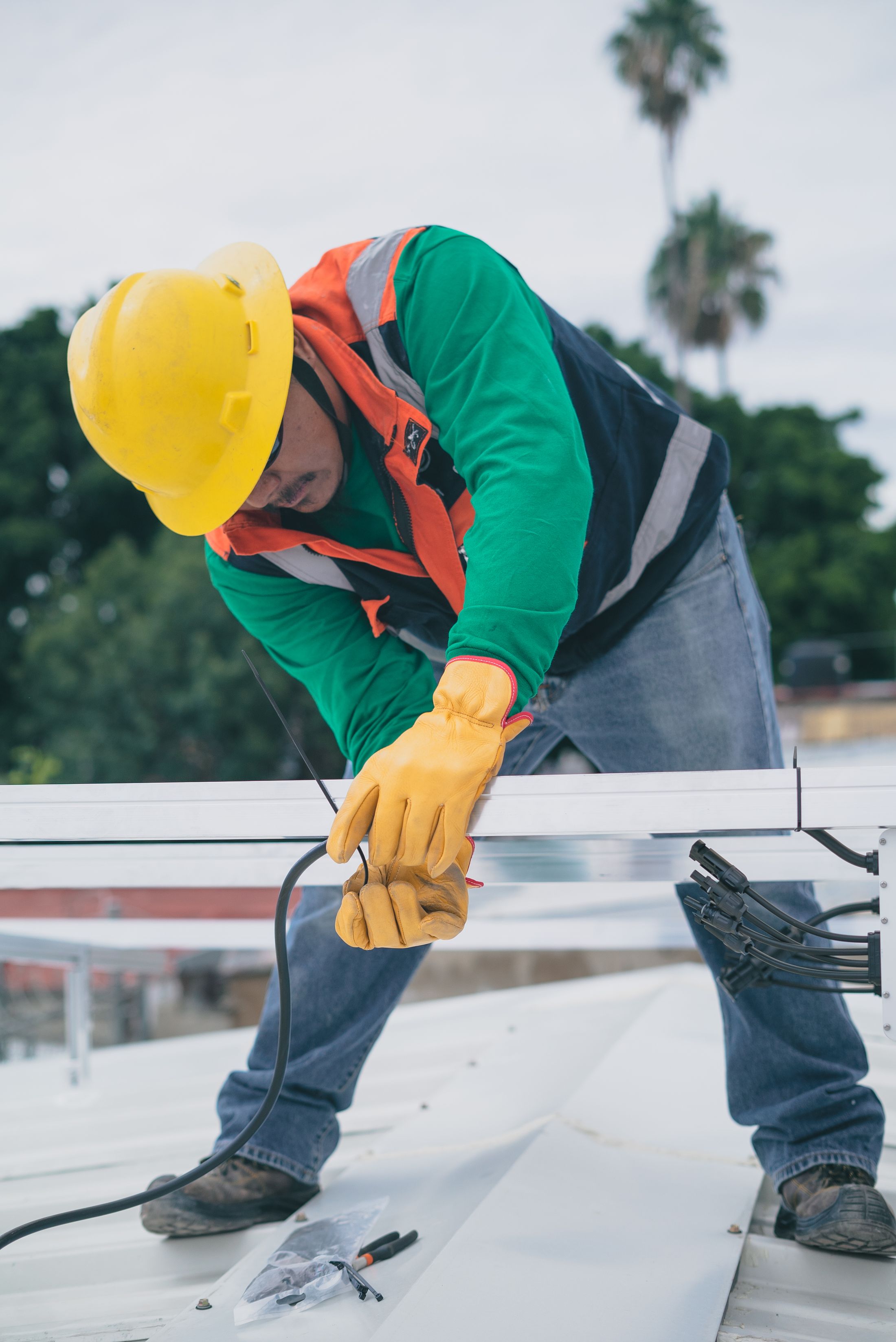 Roofer installing new metal roof sheeting